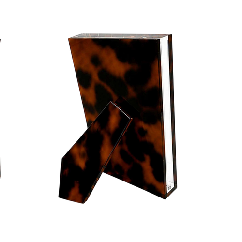 Acrylic Photo Frame 5x7 in tortoiseshell-patterned Lucite shown from the back with a matching angled easel stand and clear beveled edges.